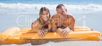 Happy cute couple in swimsuit lying on the beach