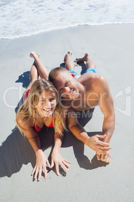 Smiling cute couple in swimsuit posing looking at camera