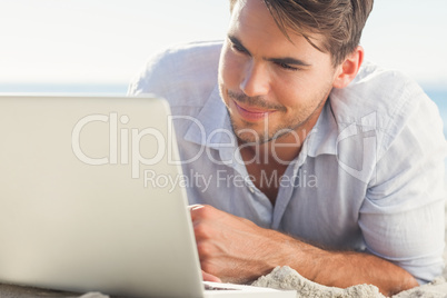 Handsome man on the beach with his laptop Handsome man on the beach with his laptop