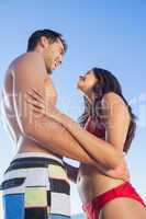 Cheerful cute couple in swimsuit holding each other