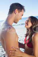 Cheerful cute couple in swimsuit holding one another