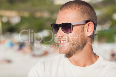 Handsome young man wearing sunglasses looking away