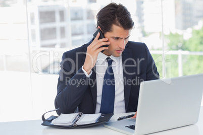 Concentrated businessman having a phone call and working on his