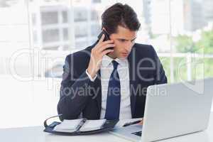 Concentrated businessman having a phone call and working on his