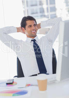 Smiling businessman relaxing on his swivel chair