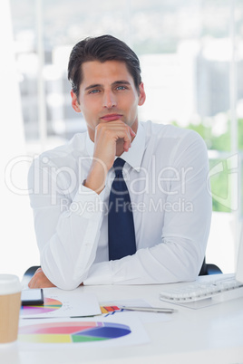 Peaceful businessman posing touching his chin