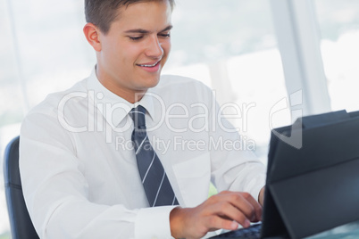 Cheerful young businessman working on his tablet pc