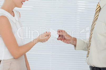 Businesswoman giving her business card to colleague