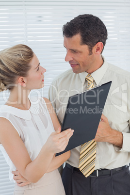 Attractive coworkers analyzing documents together