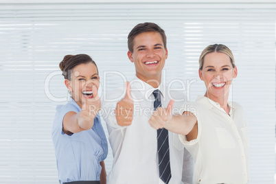 Smiling colleagues posing with thumbs up