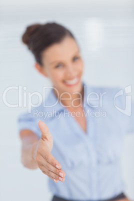 Cheerful businesswoman stretching her hand to camera