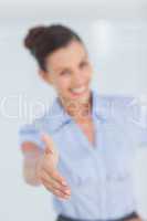 Cheerful businesswoman stretching her hand to camera