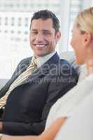 Cheerful businessman looking at his attractive blond colleague