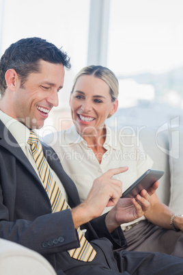 Cheerful businessman working with his colleague looking at him