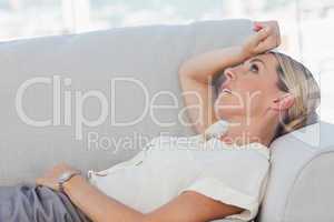 Exhausted businesswoman lying on sofa