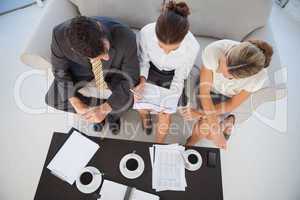 Overhead view of colleagues working and having coffee together