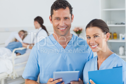 Portrait of surgeons with doctor attending patient on background