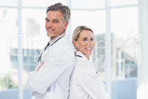 Smiling doctors posing together back to back