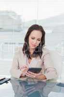 Concentrated businesswoman working on her tablet pc