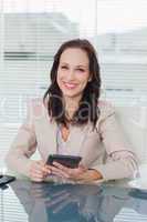Smiling businesswoman working on her tablet pc