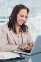 Smiling businesswoman typing on her laptop