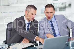 Serious businessmen working on their laptop