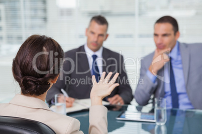 Brown haired woman talking to her interviewers