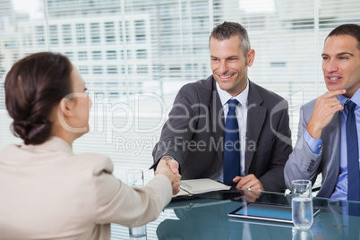 Brown haired woman shaking hands with her future employer