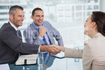 Cheerful young woman shaking hands with her future employer