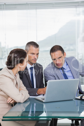 Serious colleagues working together on their laptop