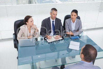 Concentrated business team interviewing experienced man