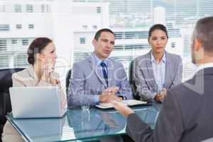 Serious business team interviewing experienced man