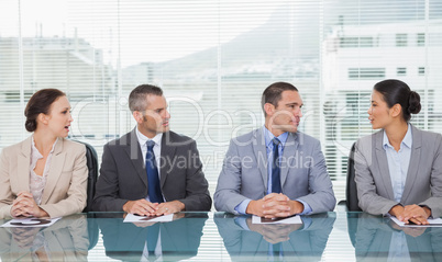Business people sitting straight talking together