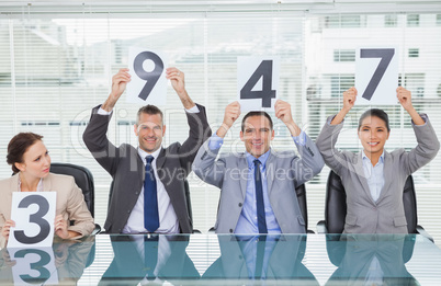 Cheerful interview panel holding signs giving marks