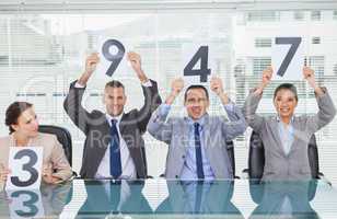 Cheerful interview panel holding signs giving marks