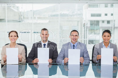 Smiling interview panel holding white paper
