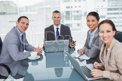 Smiling business people working together with their laptop