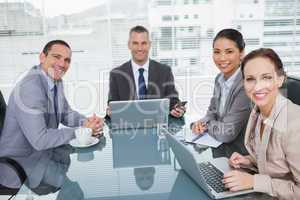 Smiling business people working together with their laptop