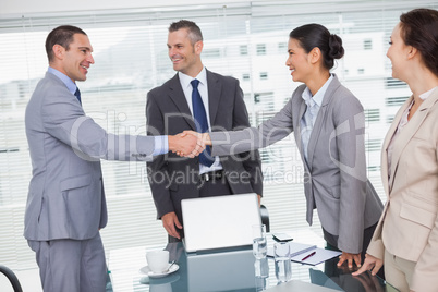 Cheerful business people meeting and shaking hands