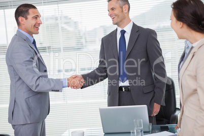 Smiling businessmen standing and shaking hands