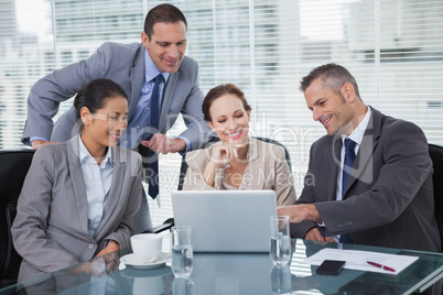 Relaxed colleagues analyzing documents on their laptop