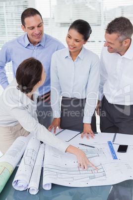 Happy architects interacting and analyzing plans together