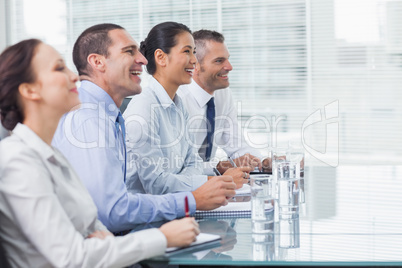 Coworkers smiling while listening to presentation