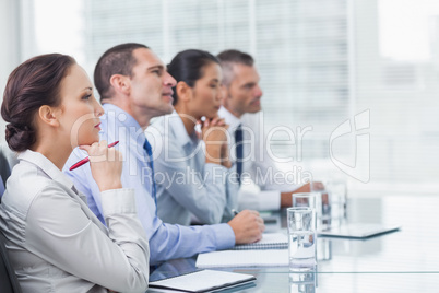 Thoughtful coworkers listening to presentation