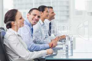 Businessman smiling at camera while his colleagues listening to