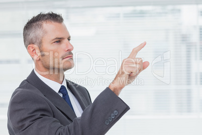 Pensive businessman pointing out while looking away