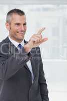 Cheerful businessman pointing and looking straight ahead