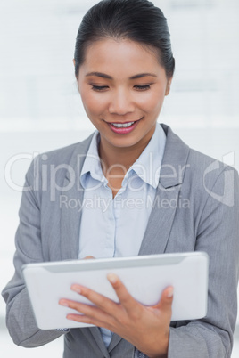 Happy businesswoman posing scrolling on her tablet pc