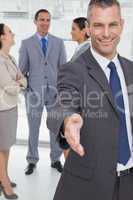 Cheerful businessman introducing himself holding out his hand