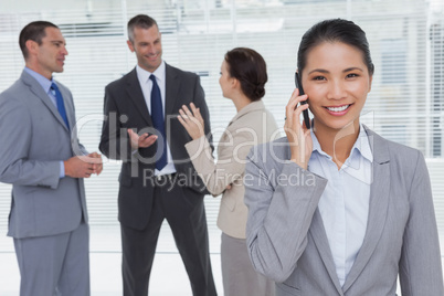 Businesswoman on the phone while colleagues talking